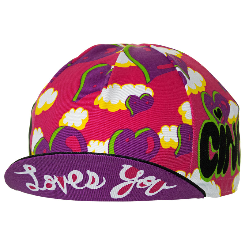 Side view of the Cinelli Ana Benaroya Heart Cotton Cycling Cap. See the Cinelli logos on the top of the peak and on each side in amongst that stunning pink, purple, white and black design.